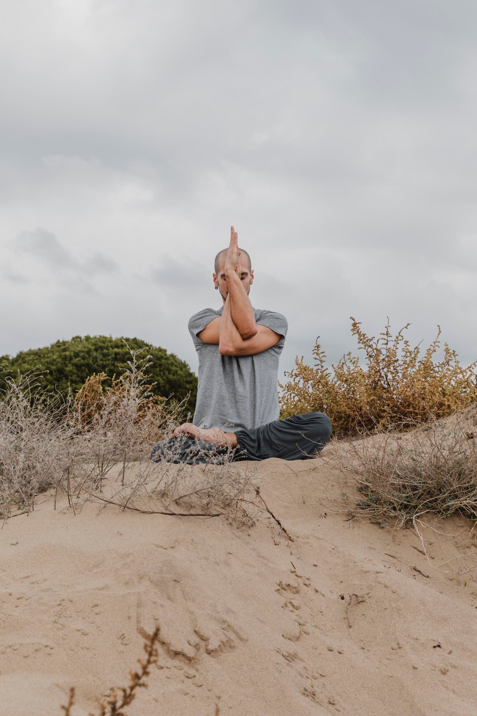 front view man outside meditating while doing yoga
