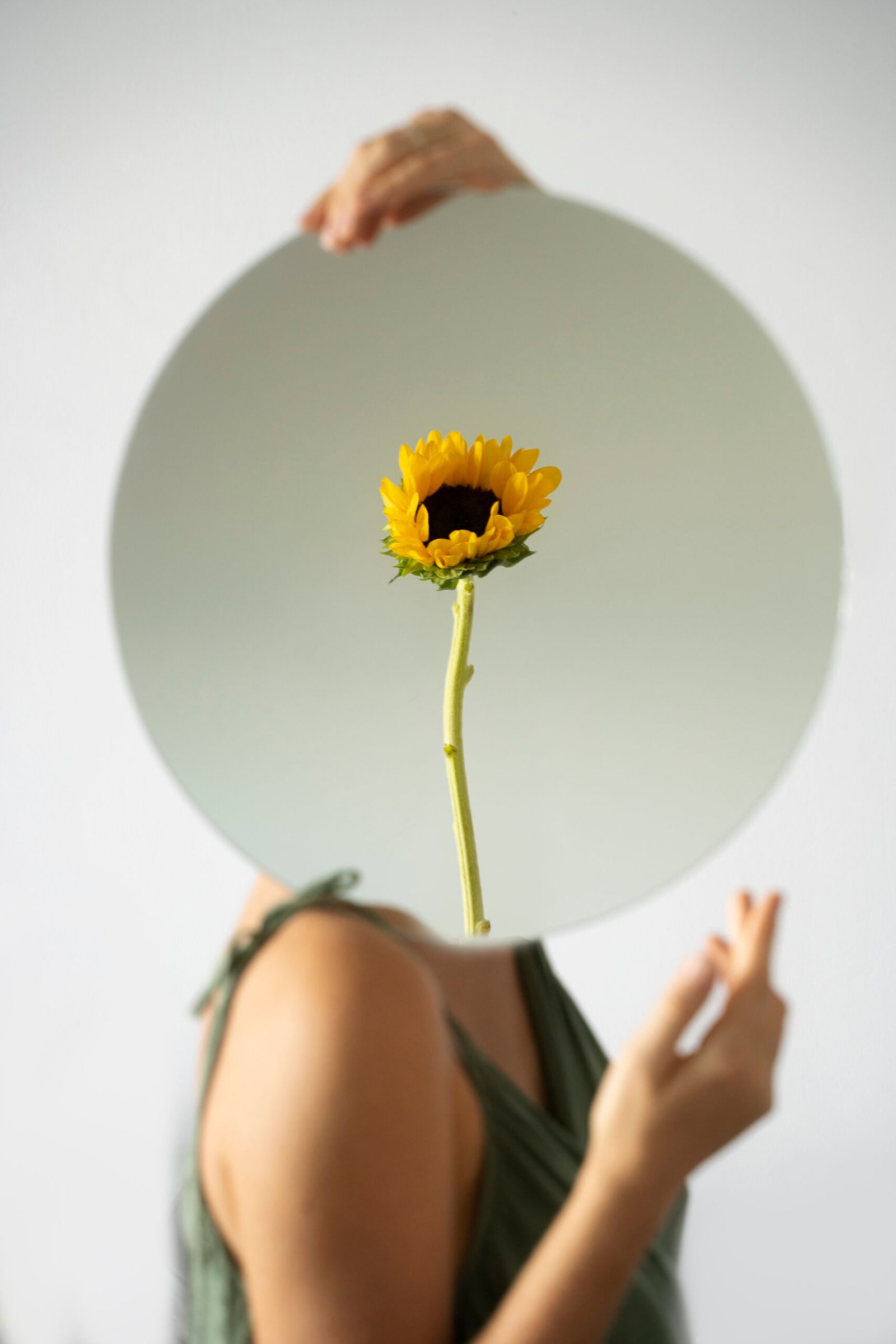 woman posing with round mirror flower